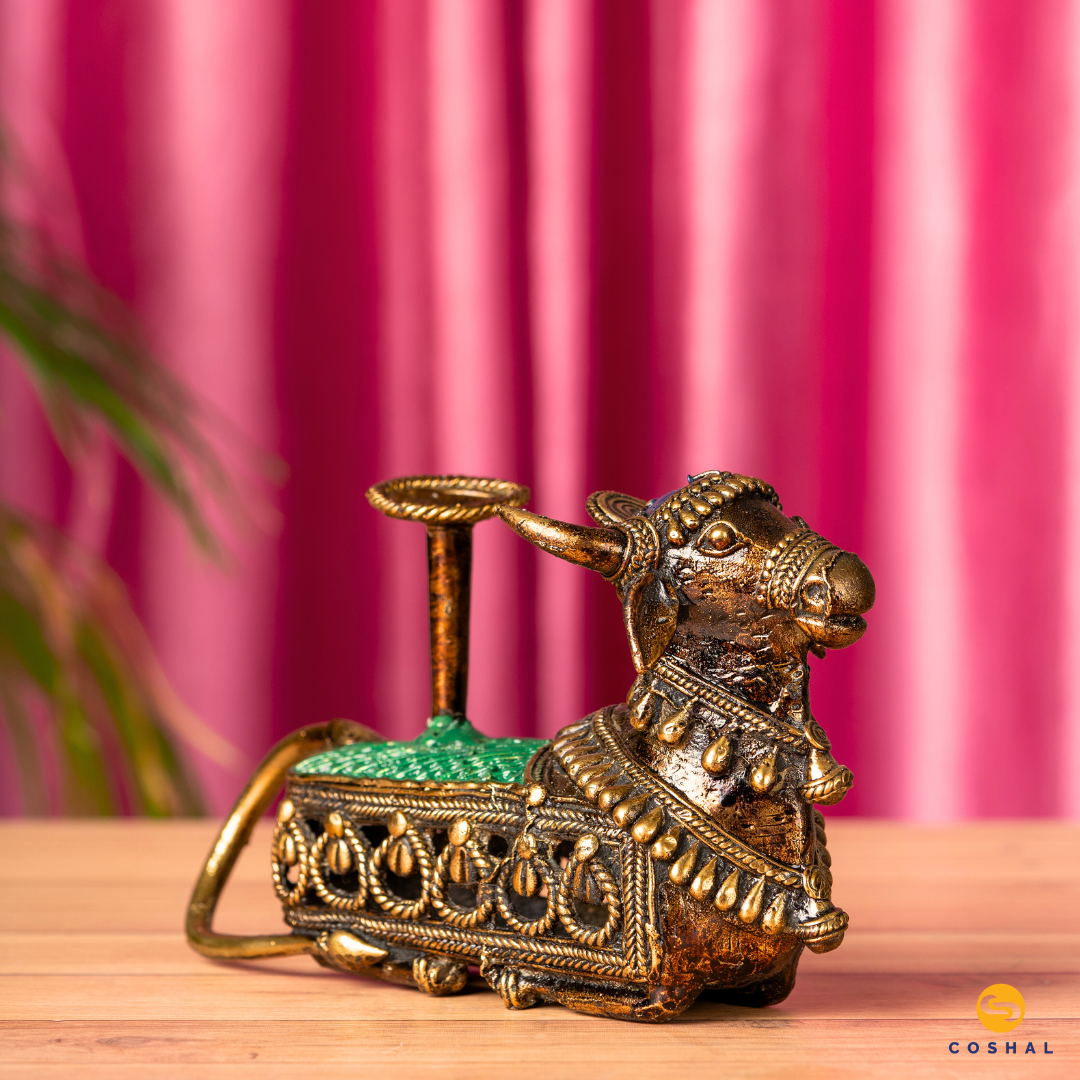 Nandi, the sacred bull, is intricately detailed using the ancient Dhokra technique—a method of non-ferrous metal casting practiced for centuries. The result is a stunning candle holder that not only radiates warm, flickering light but also pays homage to Indian heritage.