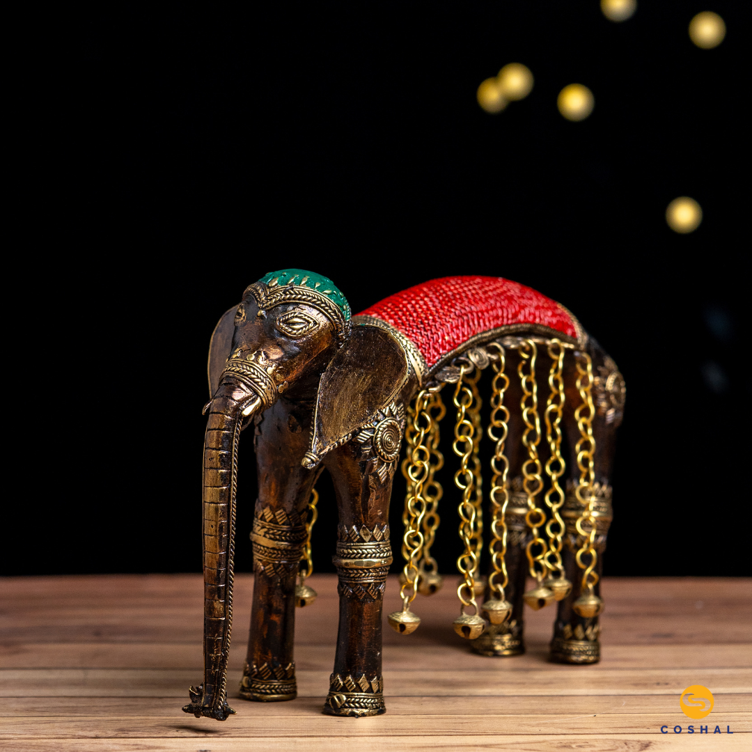 Elevate your space with the enchanting presence of the Coshal Dhokra Brass Elephant With Bells. 
