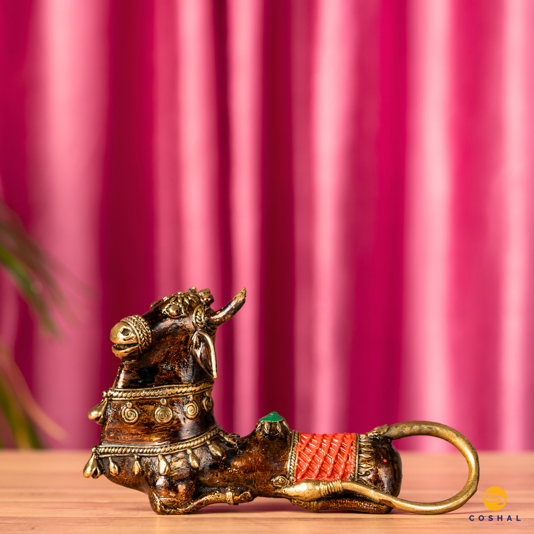 Nandi, the sacred bull and divine vehicle of Lord Shiva, is portrayed with intricate details and a timeless charm. The Dhokra technique, an age-old method of metal casting, brings out the fine nuances of this handmade masterpiece.