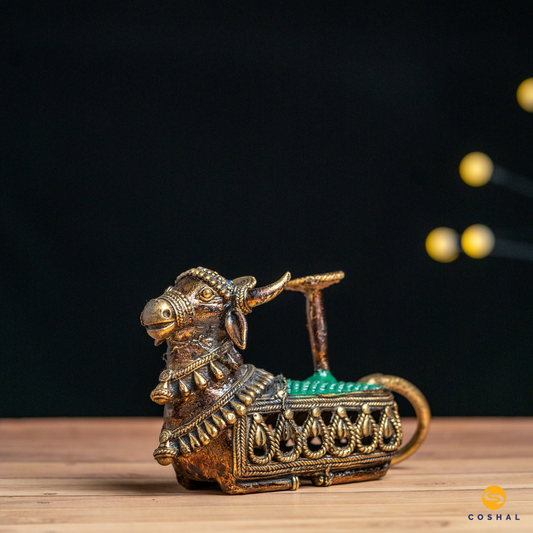 Nandi, the sacred bull, is intricately detailed using the ancient Dhokra technique—a method of non-ferrous metal casting practiced for centuries. The result is a stunning candle holder that not only radiates warm, flickering light but also pays homage to Indian heritage.