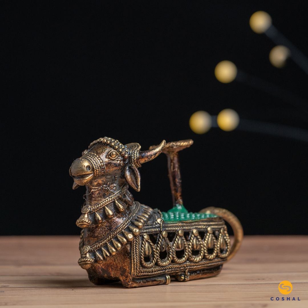 Handcrafted Nandi Candle Holder, the sacred bull, is intricately detailed using the ancient Dhokra technique—a method of non-ferrous metal casting practiced for centuries. The result is a stunning candle holder that not only radiates warm, flickering light but also pays homage to Indian heritage.